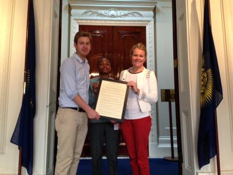 Clare Barrell, Will Stone and Samuel Musembi pose for a picture with the Youth Sport Charter 