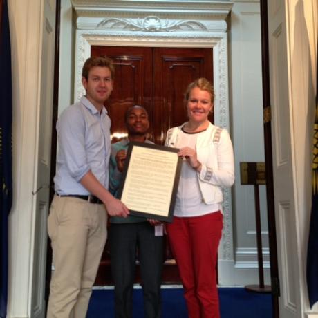 Clare Barrell, Will Stone and Samuel Musembi pose for a picture with the Youth Sport Charter 